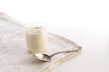 Yogurt in glass jar with spoon