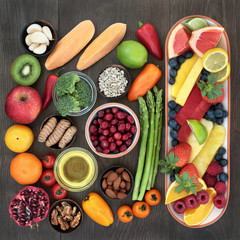 Health food for heart fitness concept with super foods of fresh fruit, vegetables, seeds, nuts, herbs and spice  providing high levels of omega 3 fatty acids, vitamins, anthocyanins and antioxidants.