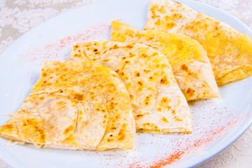 Indian naan bread with spices on white plate