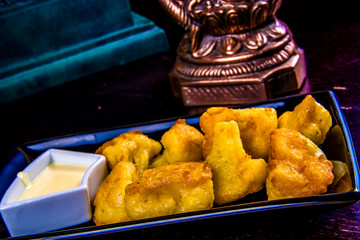 Deep Fried cauliflower with sauce on black plate