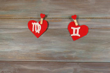 Virgo and twins. signs of the zodiac and heart. wooden backgroun