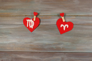 Virgo and the Aries. signs of the zodiac and heart. wooden backg