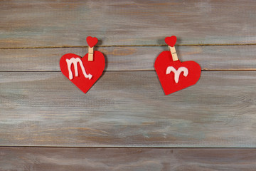 Scorpio and Aries. signs of the zodiac and heart. wooden backgro