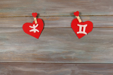 Pisces and twins. signs of the zodiac and heart. wooden backgrou