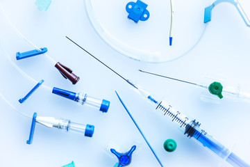 Central venous catheter insertion set with needle,syringe and plastic tubes on blue background - obrazy, fototapety, plakaty