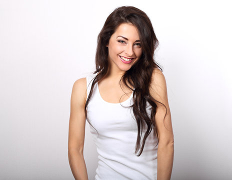 Beautiful positive woman in white shirt and long hair toothy smile on white background