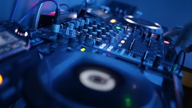 Dj hands playing and mixing music in a nightclub