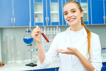 Young chemistry teacher in school laboratory work showing vial