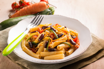 pasta with beans carrot zucchinis and fresh tomatoes, selective focus