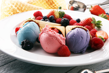 Set of ice cream scoops of different colors and flavours with blueberries, raspberries and blackberries.