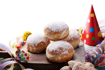 German donuts with jam and icing sugar. Carnival powdered sugar raised donuts with paper streamers.