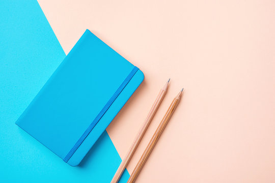 Writing Notepad Wood Pencils on Contrast Blue Peach Pink Pastel Color Background Combination. Business Education Routine Organization Planning Concept. Elegant Style Copy Space