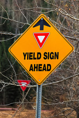 A warning Yield Sign Ahead sign in the fall