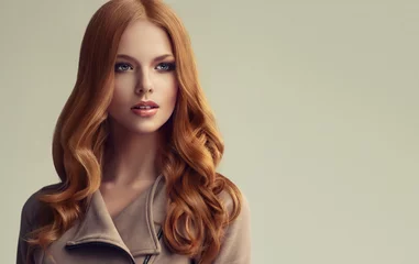 Papier Peint photo Salon de coiffure Fille rousse aux cheveux ondulés longs et brillants. Belle femme modèle avec une coiffure frisée.