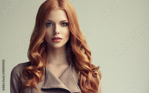 "Red head girl with long and shiny wavy hair . Beautiful 