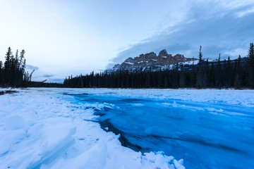 Blue glacier water flowing over ice in the bow river at Castle mountain