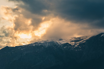 Moody clouds at sunset above rocky mountains