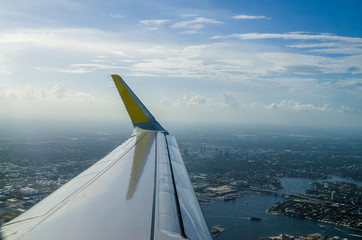 View of an airplane wing flying over the city