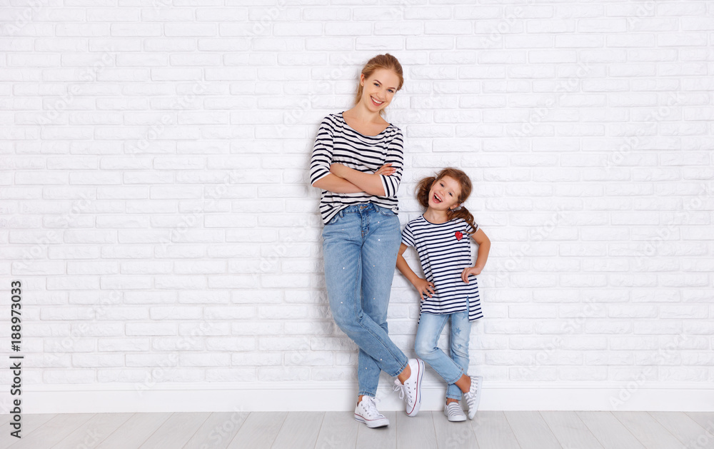 Poster happy family mother and child daughter near an empty wall