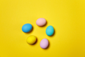 Five colorful pastel monophonic painted Easter eggs isolated on yellow background for card or postcard. Happy Easter concept. Copy space for advertisement. With place for text. Top view on eggs.