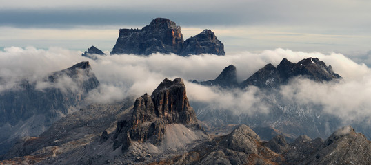 Monte Pelmo Dolomites during sunset surrounded by clouds in golden hour