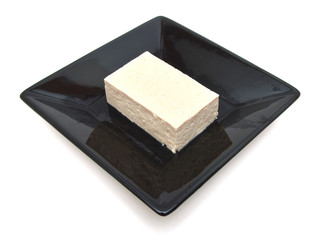 Bean curd (tofu) in plate on a white background. Protein alternative to meat.