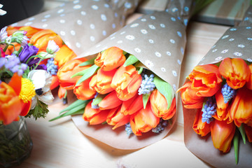 top view of beautiful pink tulips bouquet in wrapping paper on wooden table