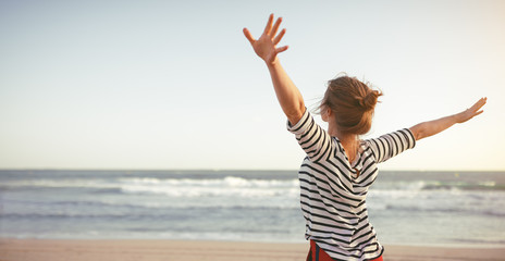 happy woman enjoying freedom with open hands on sea