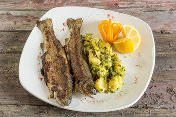 Fish Trout baked with vegetables and spices. On a wooden background. Top view.