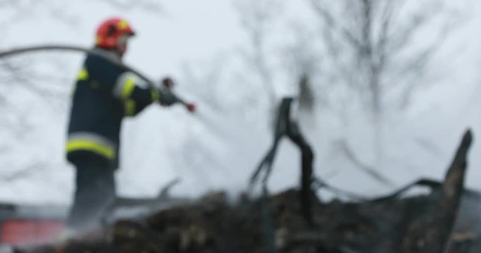 Firefighter or fireman fiting with fire on home.
