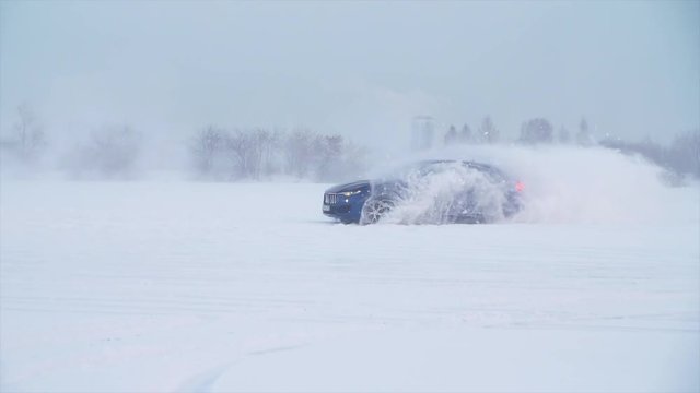 Snowy road in forest with car by and making a 180 turn slow motion . Car is making a drift in the snow. Car rides on a snowy road in winter time