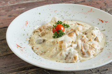 pork fillet in aromatic sauce whit noodles. On a wooden background. Top view. rustic food