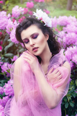Naklejka premium girl in dress in rhododendron garden