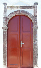 Wooden door in a stone wall in Santorini Greece