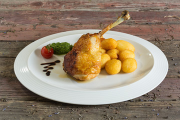 Roasted chicken legs and stuffing on a plate. On a wooden background. rustic food