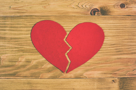 Broken heart on wooden table,relationship breakup concept.