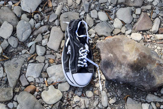 Black and white sneakers on stones. Sport shoes.