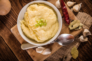 mash potatos in a white porcelain bowl on wood table 