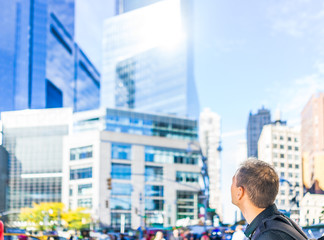 Closeup of young man's head back looking up at skyscrapers in New York City NYC Columbus Circle on...