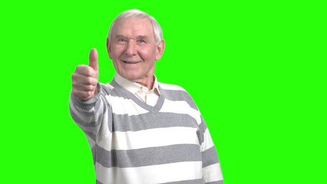 Old man showing thumb up. Smiling cheerful grandpa shows thumb up, green hromakey background.