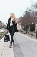 a young and attractive girl with long blond hair walking down the main city street