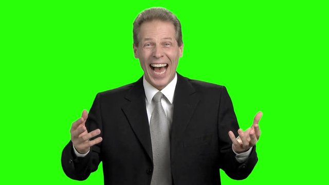 Mature businessman suddenly cheering up. Middle aged man with business suit suddenly cheering up and laughing against green hromakey background.