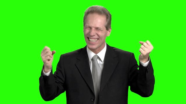 Cheerful businessman rejoicing success. Successful businessman with raising hands in green hromakey background.