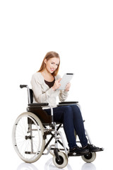 Fototapeta na wymiar Beautiful casual woman sitting on w wheelchair with tablet.