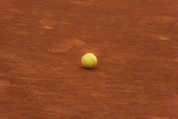 Tennis balls on red court with gray net
