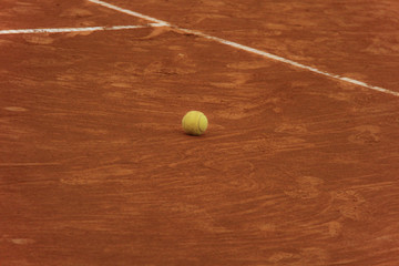 Tennis balls on red court with gray net