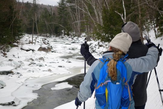 cross country skiers stop to enjoy the winter river view
