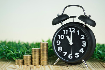 Steps of coins stack with vintage alarm clock on wooden working table with copy space for text, financial and business planning concept.