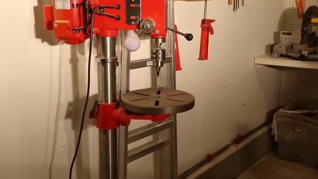 Man using a drill press to drill a hole in a piece of wood