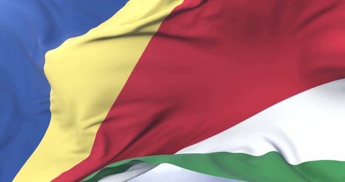 Flag of Seychelles waving at wind in slow in blue sky, loop